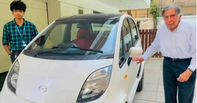 Ratan Tata sitting in a red Tata Nano Electric Vehicle