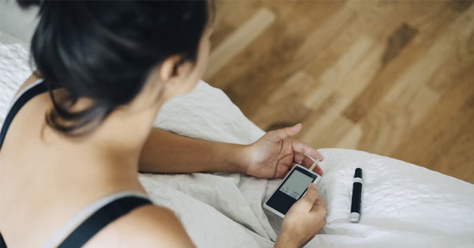 Indian woman checking her blood sugar levels due to diabetes issues