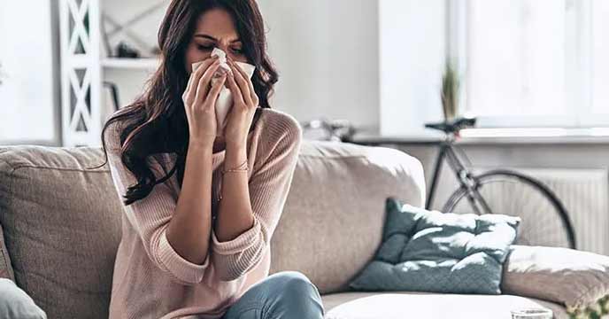 Woman sneezing after leaving an AC room