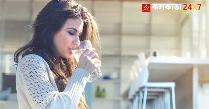 Person Drinking Cold Water From a Glass