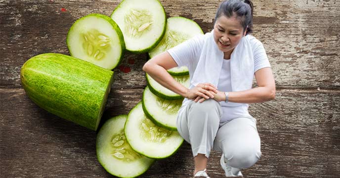 A bowl of fresh cucumbers on a wooden table