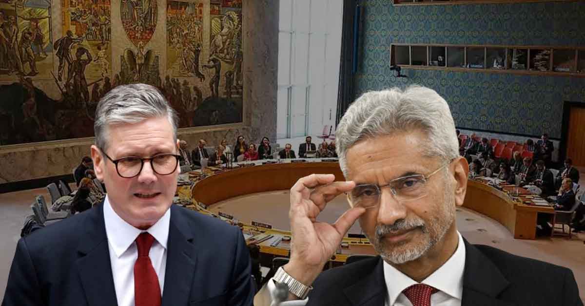 Indian External Affairs Minister S. Jaishankar standing with UK Prime Minister Rishi Sunak, both in formal attire, engaging in conversation against an official setting. Jaishankar is gesturing with his hand, while Sunak listens attentively, highlighting the diplomatic interaction between the two leaders